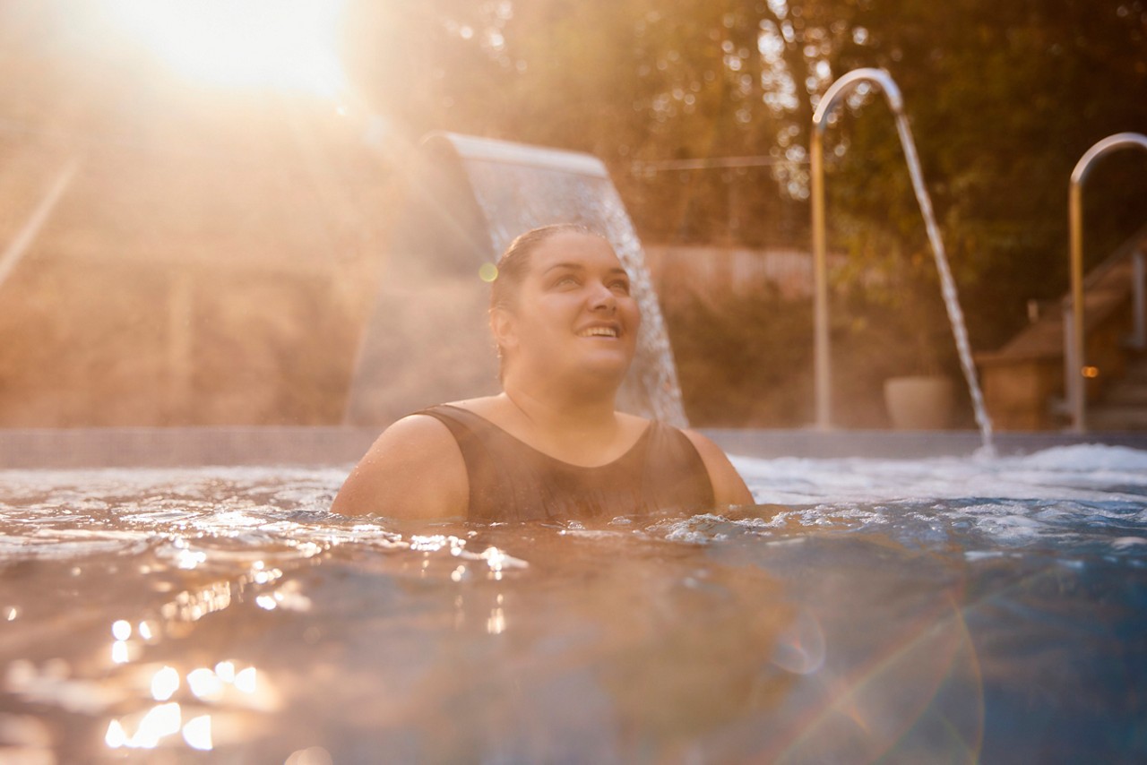 Woman soaking in an outdoor pool.