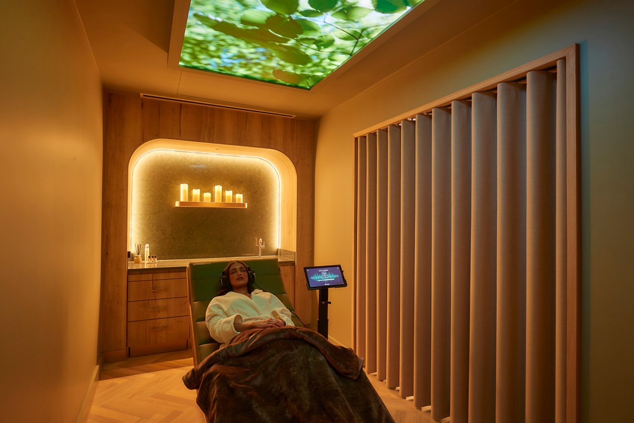 Woman laid back wearing a fluffy spa robe.