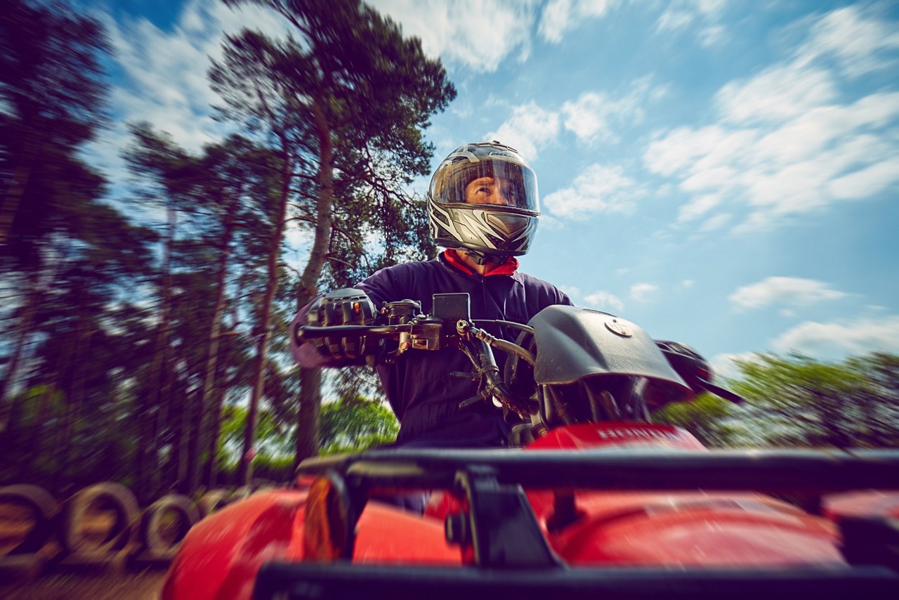 Man riding a quad bike through the forest.