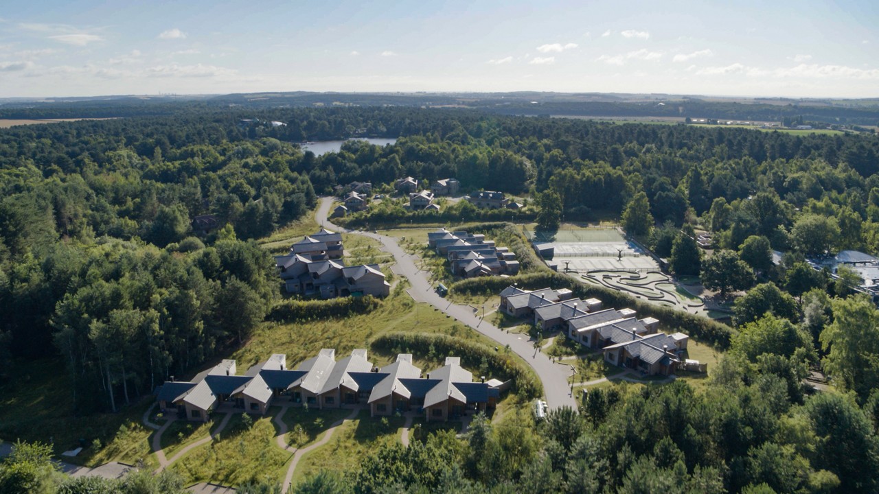 An aerial shot of the lodges at Sherwood Forest amongst the trees.