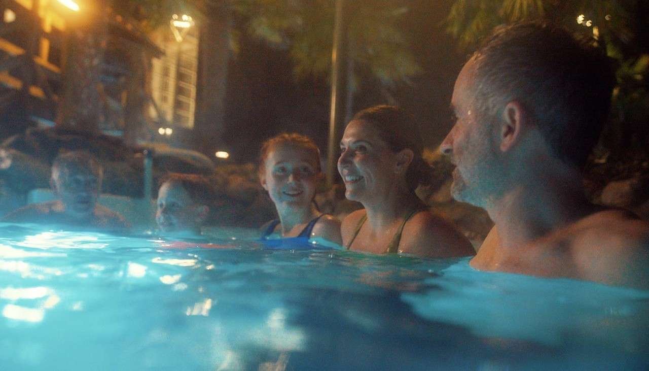 A family in the Subtropical Swimming Paradise at night.